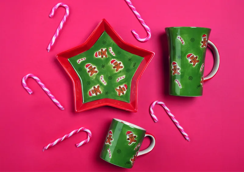Becher und Sternteller Gingerbreadmen von Mila mit Zuckerstangen auf pinkem Grund