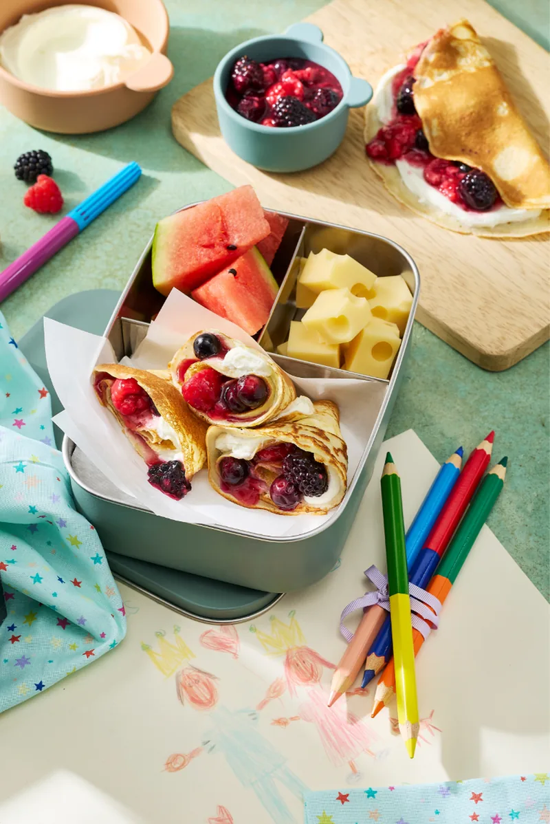 Brotdose mit Pfannkuchen, Obst und Buntstiften