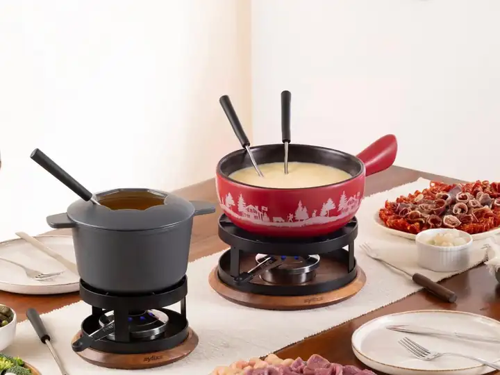 Zwei Fondue Sets von Zyliss auf einem gedeckten Esstisch