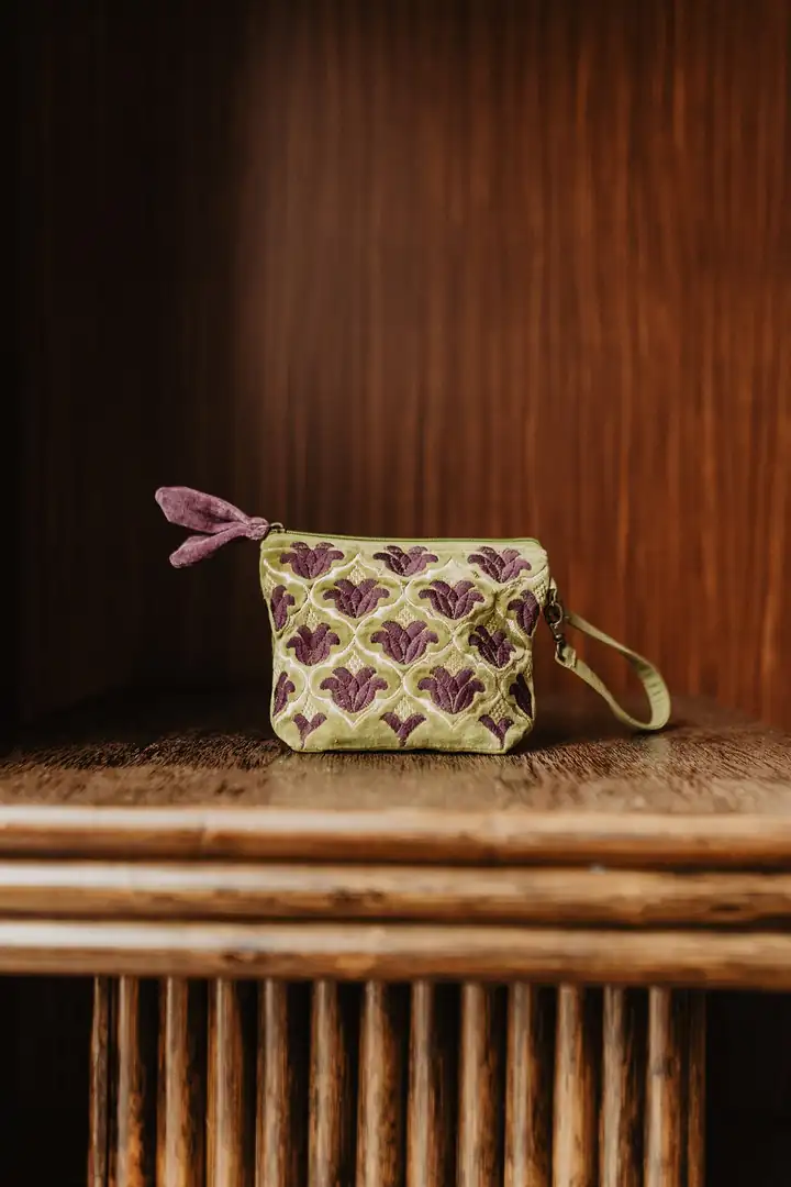 Etui LEELA von Handed By in Grün mit lila Muster auf einem Holzregal