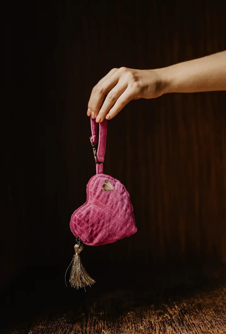 Herzförmiges Etui LEELA in Pink mit goldener Quaste an einer Hand