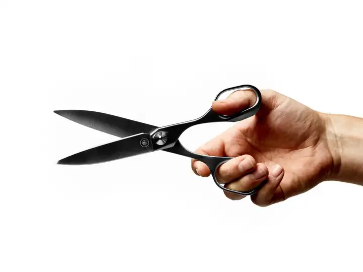 Hand hält die geöffnete HORL Schere mit dem Logo auf der Klinge