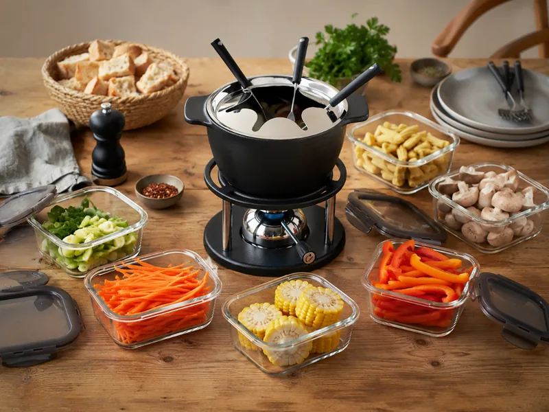 Kisag Fondue Twin auf einem gedeckten Tisch mit Beilagen
