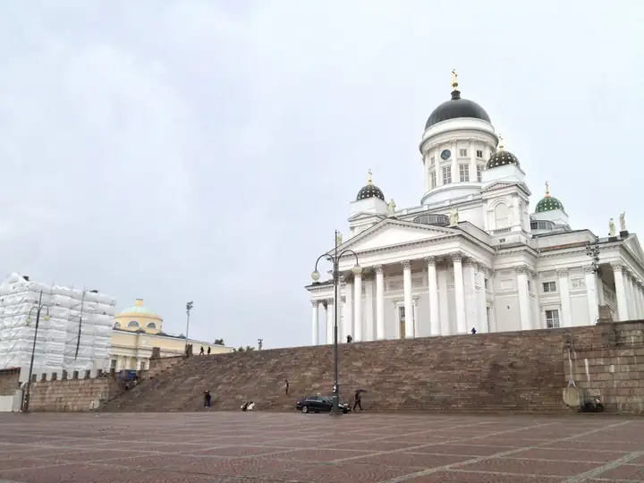Weißer Dom von Helsinki mit grüner Kuppel über der breiten Treppe am Senatsplatz