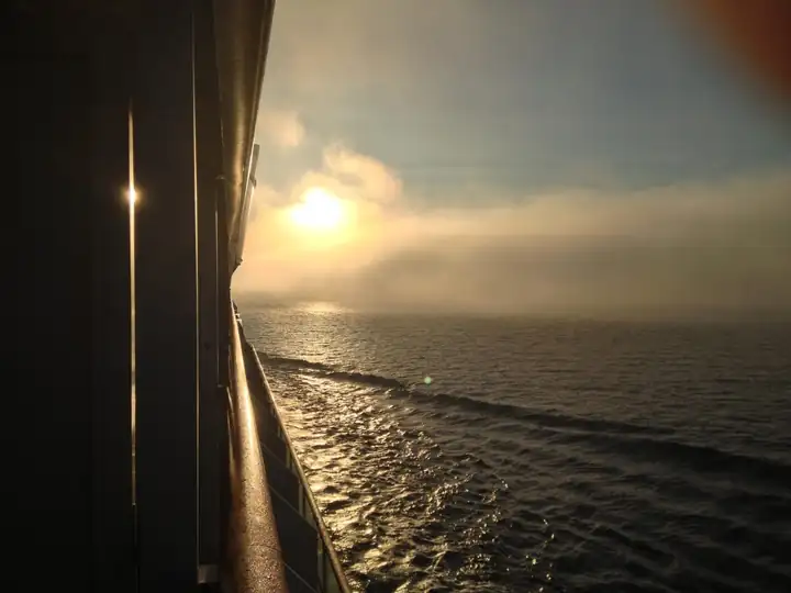 Sonne hinter Nebel über der Ostsee, vom Balkon an der Bordwand fotografiert