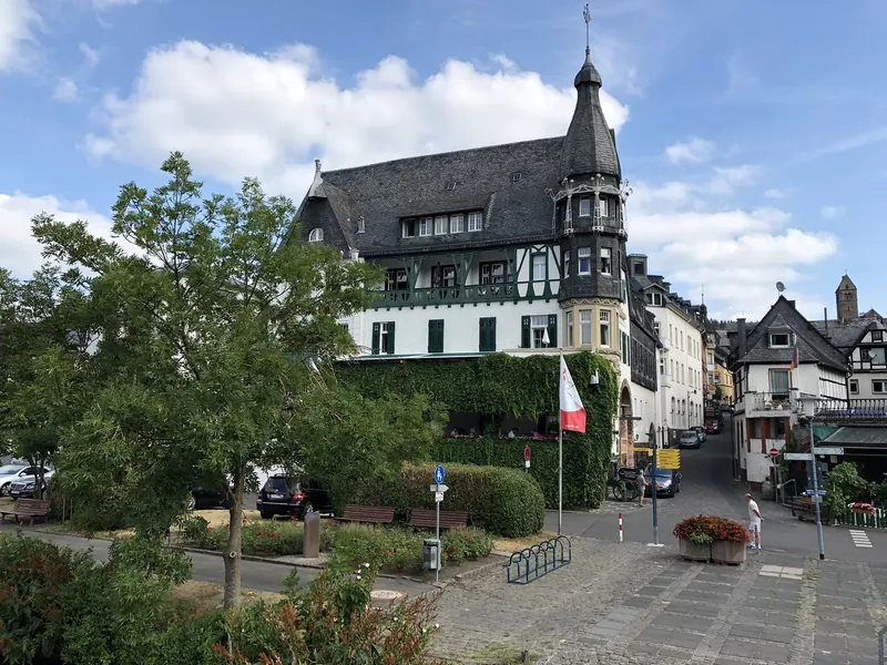 Das Jugendstilhotel Bellevue in Traben Trarbach mit Schieferdach, Fachwerk und spitzem Turm unter blauem Himmel