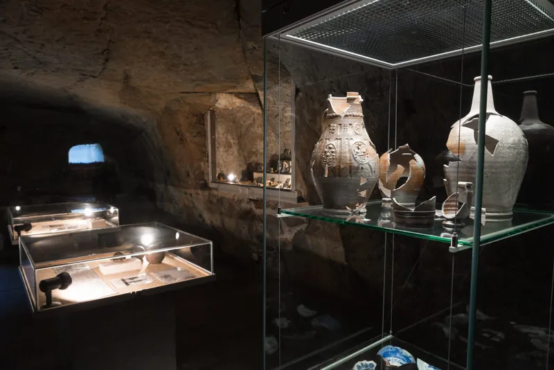Ausstellung mit Keramikgefäßen in einem Felsenraum der Burg Regenstein