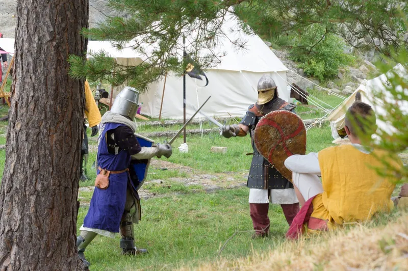 Zwei Ritter in Rüstung beim Schaukampf, Zuschauer im Gras