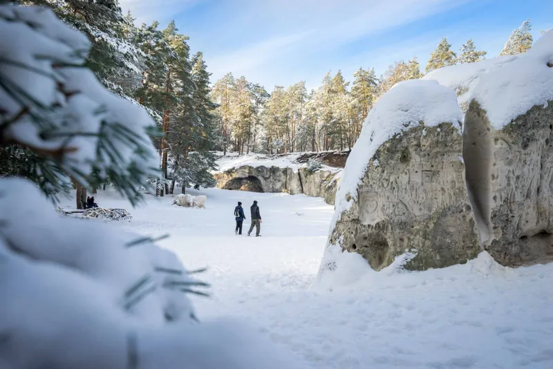 Zwei Wanderer an einem Wintertag vor den Sandhöhlen im Heers bei Blankenburg