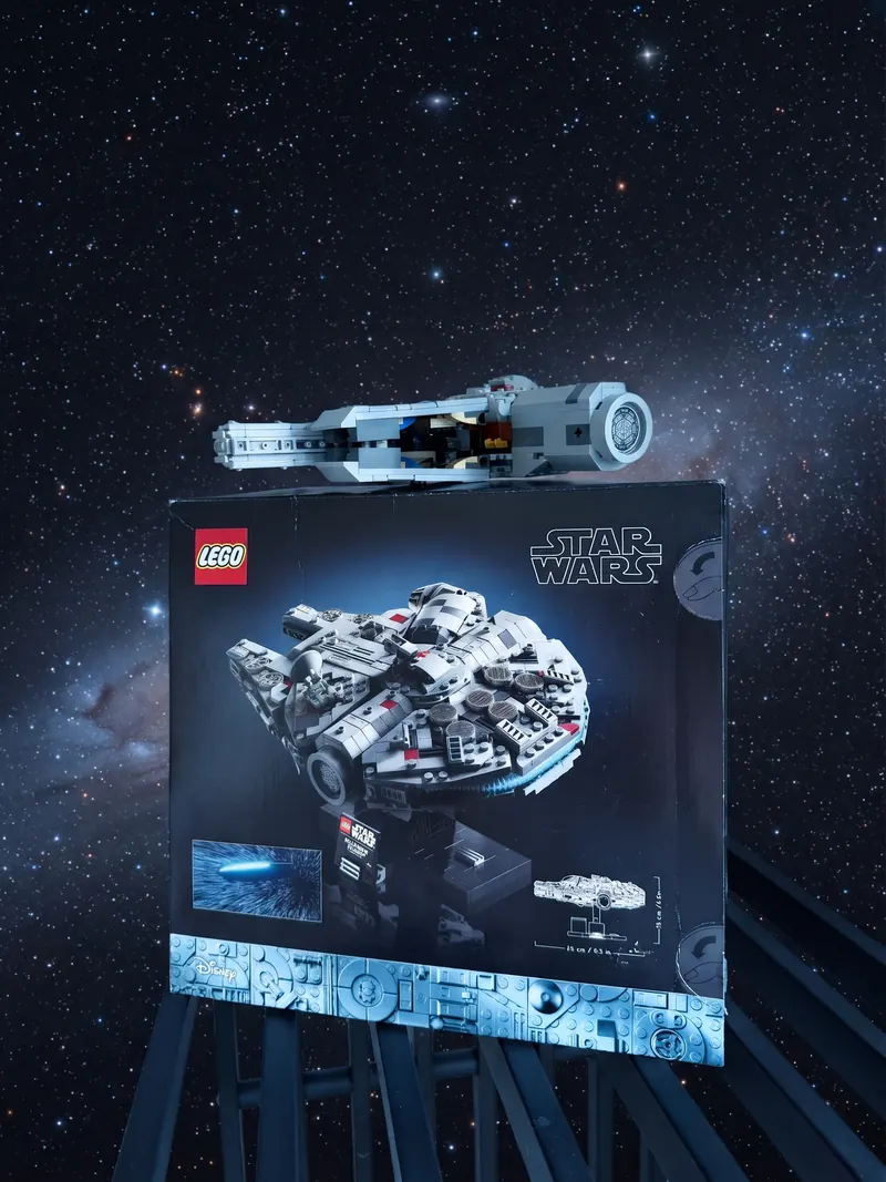 Fertig gebauter LEGO Millennium Falcon von der Seite auf dem Karton des Sets 75375, dahinter ein Sternenhimmel