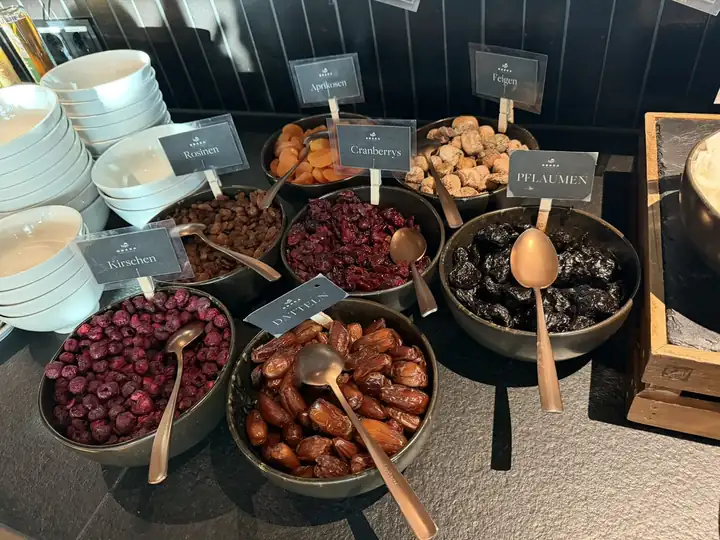 Schalen mit getrockneten Cranberrys, Kirschen, Pflaumen, Aprikosen und Feigen auf dem Frühstücksbuffet, mit Schildern