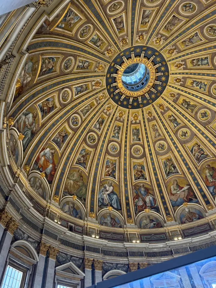 Blick nach oben in die goldene Kuppel des Petersdoms mit Kassetten und Mosaiken