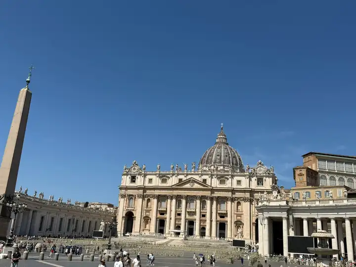 Petersplatz mit dem Obelisken und dem Petersdom unter blauem Himmel