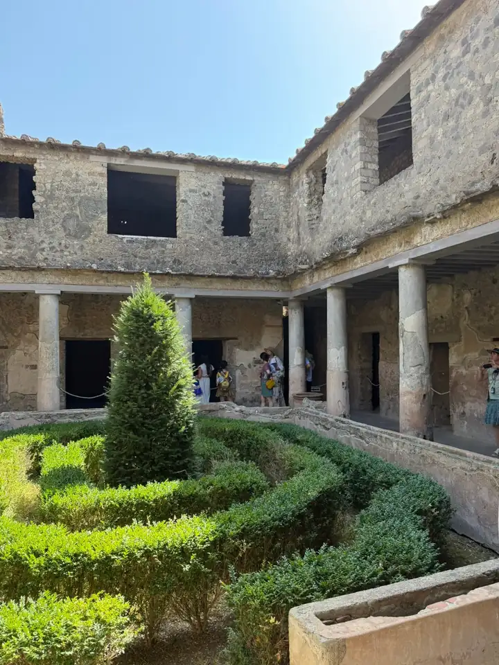 Säulenhof eines Hauses in Pompeji mit Buchsbeeten und einer Zypresse