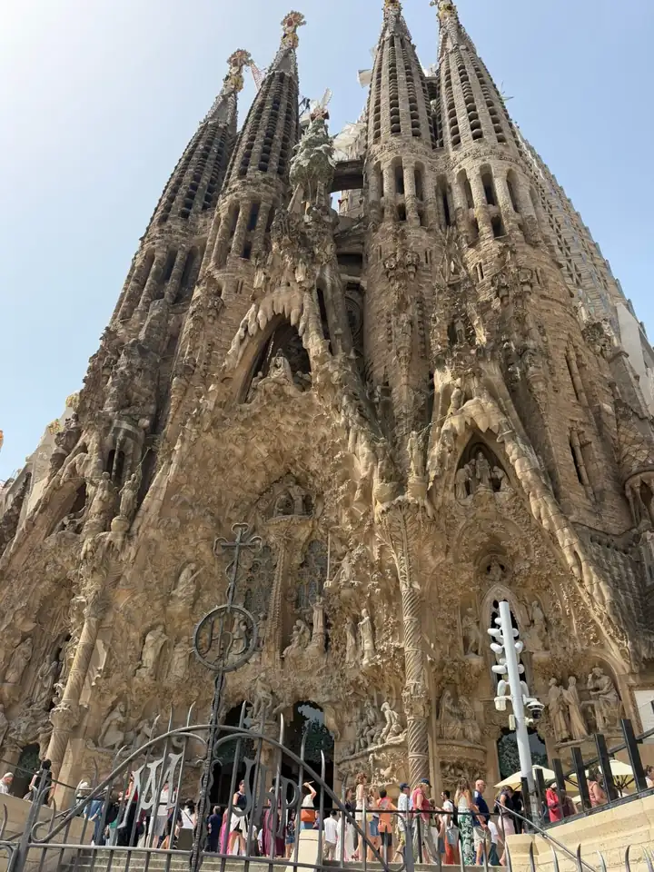 Fassade der Sagrada Família mit Türmen und Figuren, von unten fotografiert