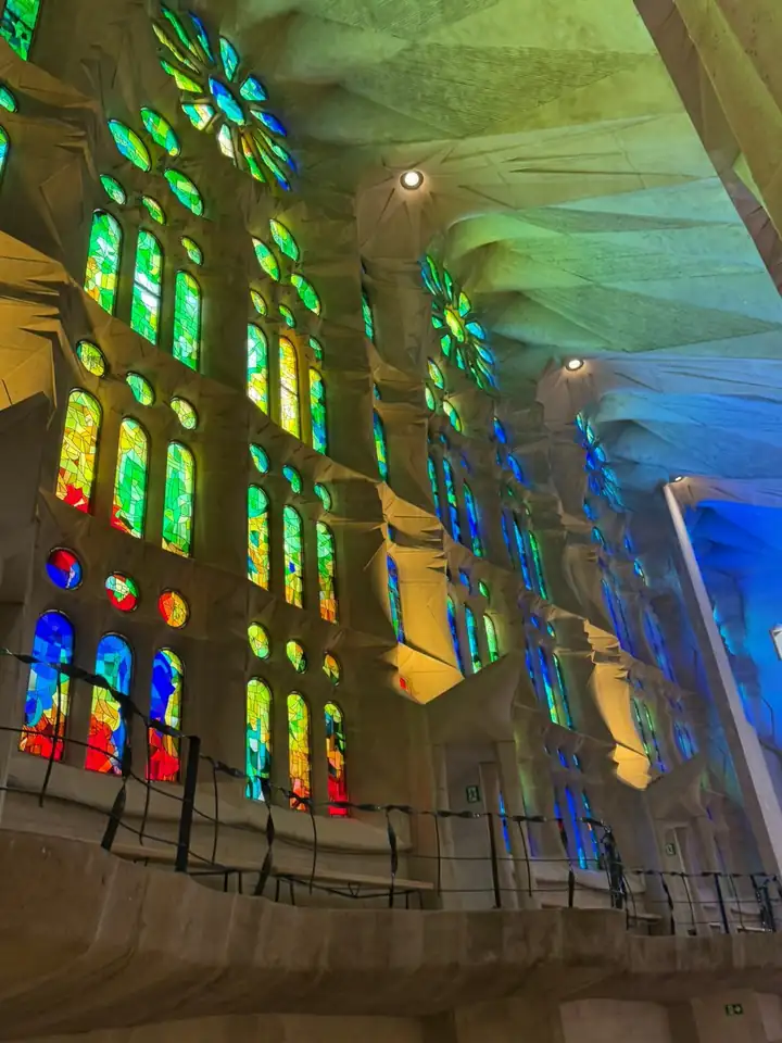 Buntes Licht aus grünen, blauen und orangen Kirchenfenstern in der Sagrada Família