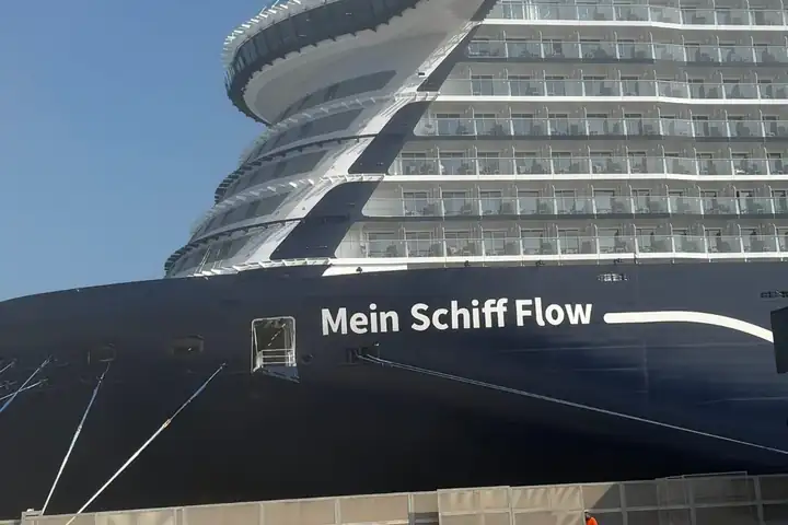 Bug der Mein Schiff Flow mit dem Schriftzug am dunkelblauen Rumpf, darüber die geschwungenen Decks mit Balkonen