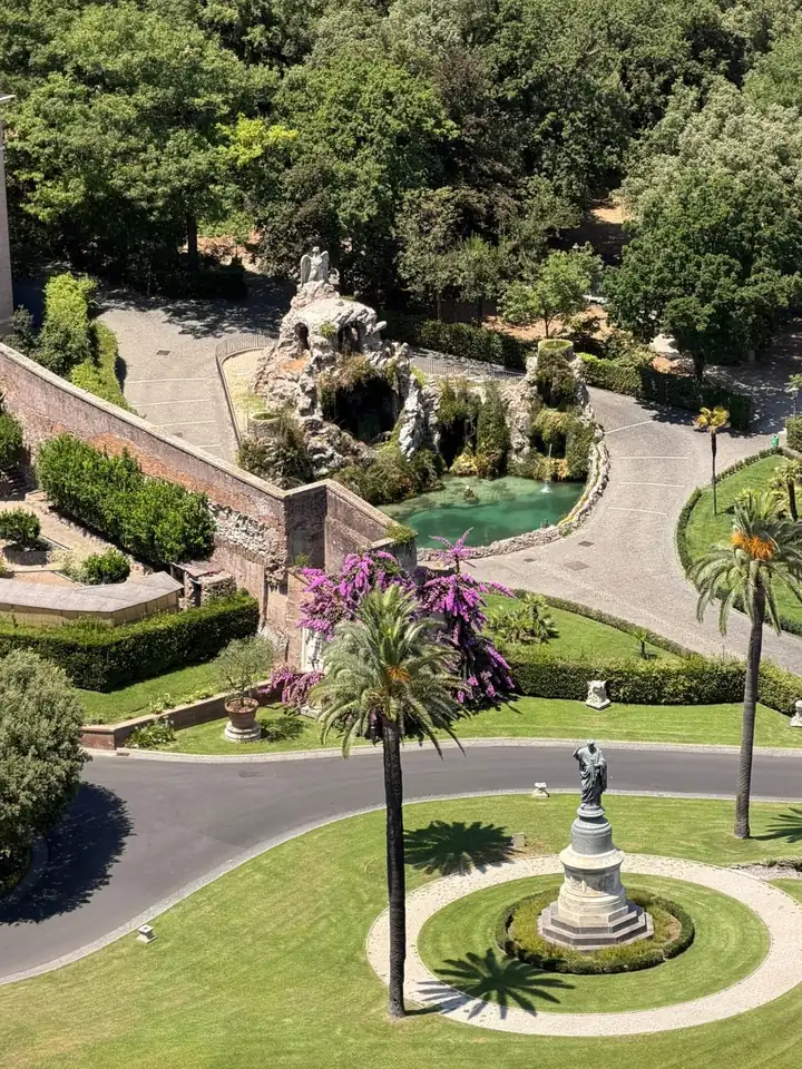 Blick von oben auf die Vatikanischen Gärten mit Palmen, Wegen und einem Brunnen