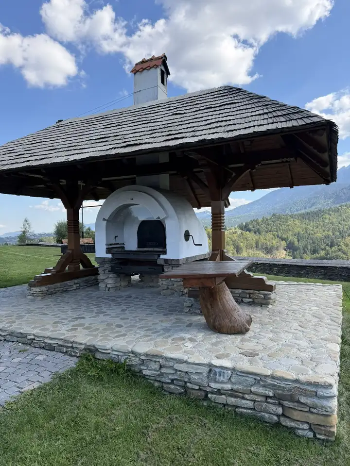 Holzofen unter einem Pavillon mit Schindeldach bei MATCA