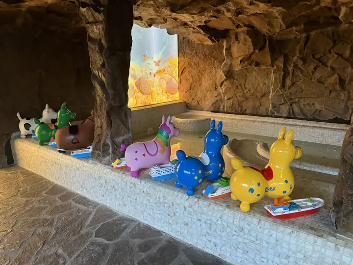 Bunte Hüpftiere aus Gummi auf dem Beckenrand in der Grotte des Felsenbads