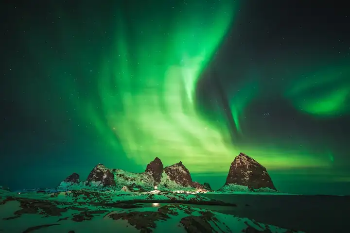 Grünes Nordlicht über den Gipfeln von Sanna bei Nacht