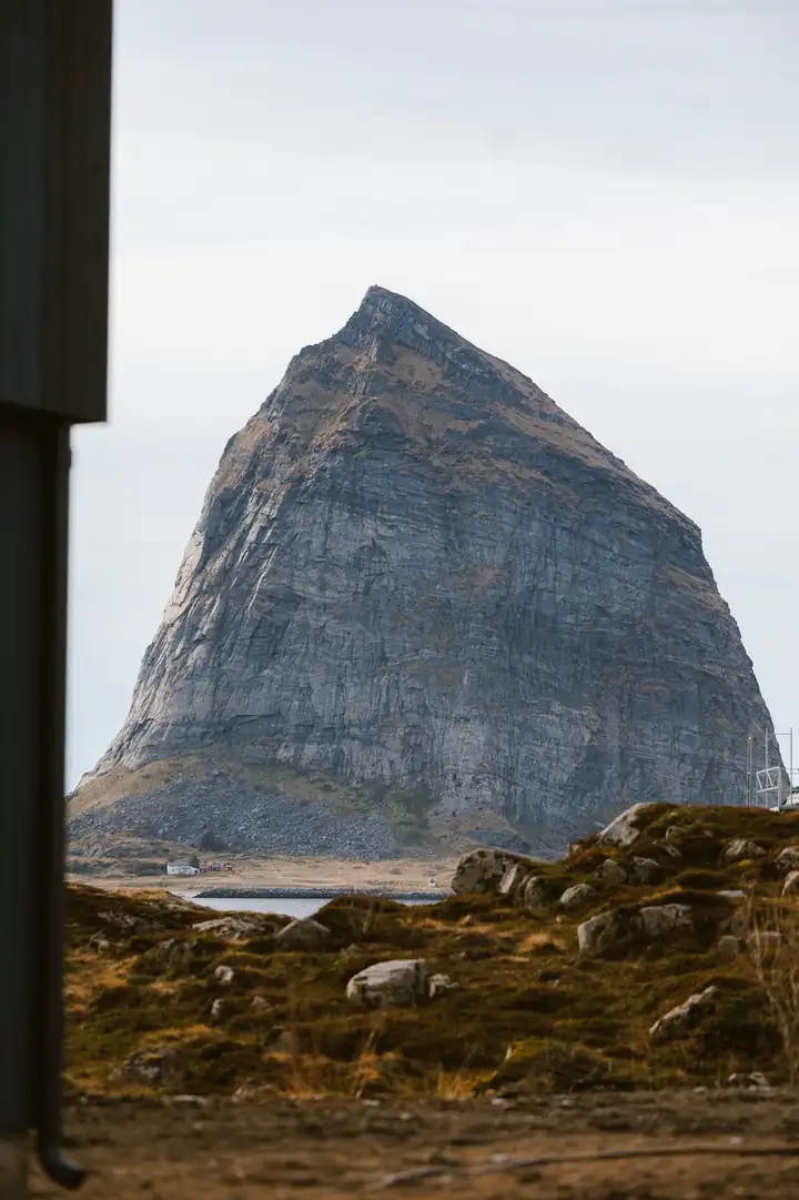 Der Trænstaven, ein steiler Felsberg auf Sanna, durch einen Fensterrahmen gesehen